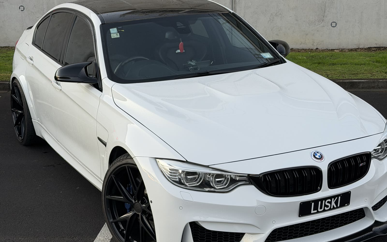2015 BMW M3 F80 front angle, showing carbon fibre roof and gloss black grilles