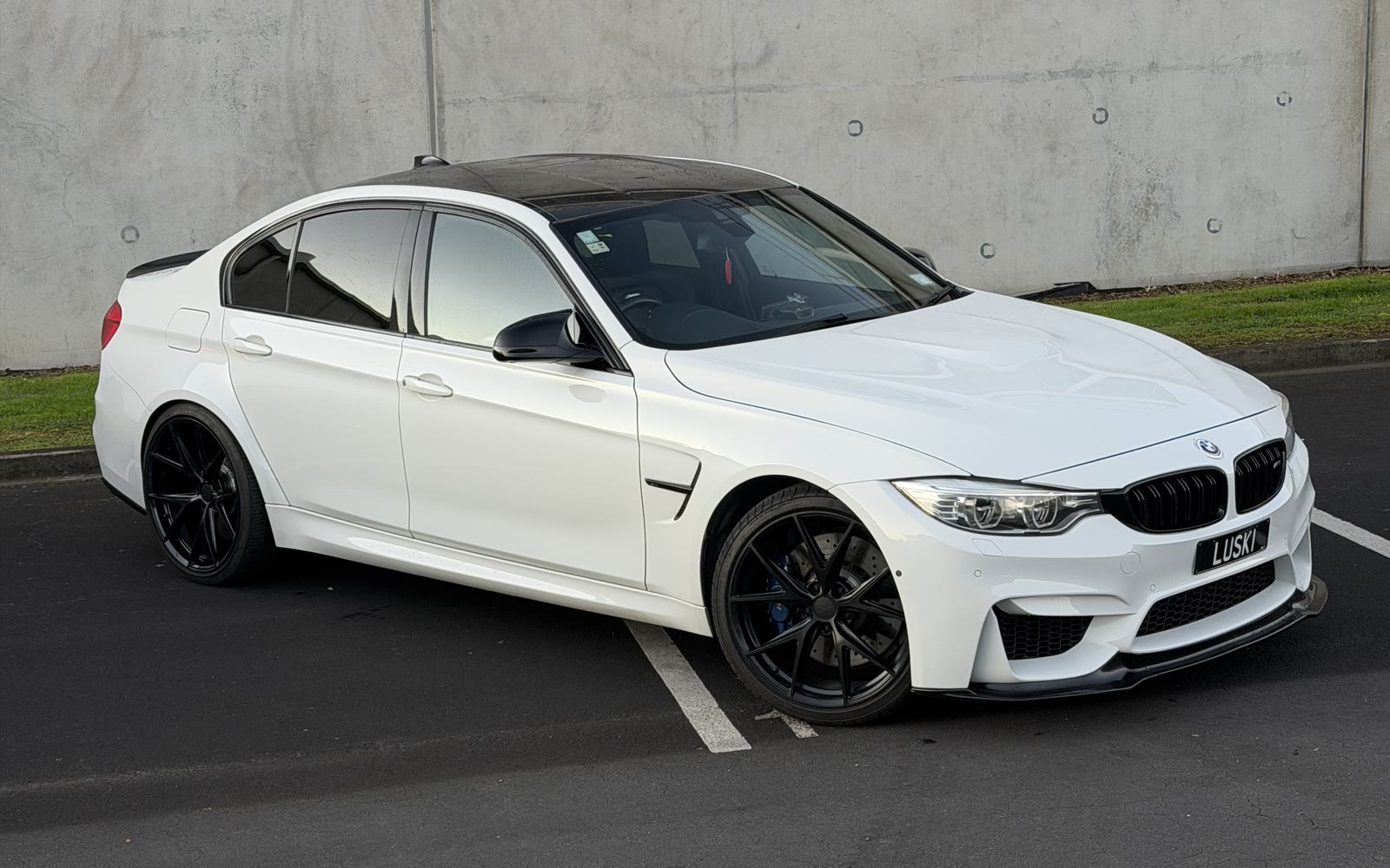 2015 BMW M3 F80 driver's side profile on black multi-spoke wheels